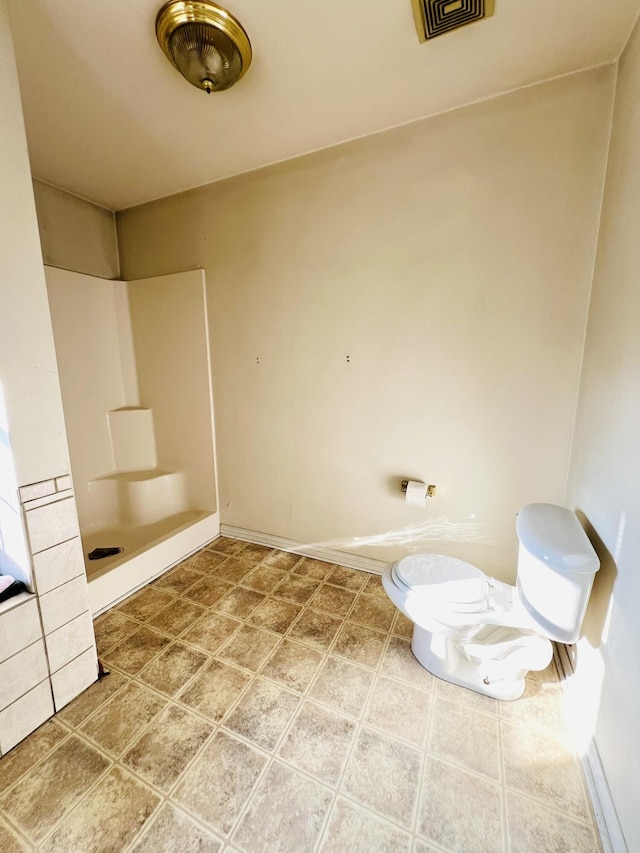 bathroom featuring walk in shower and toilet