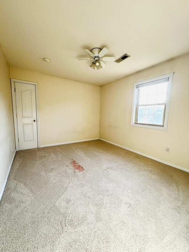 unfurnished room with baseboards, ceiling fan, visible vents, and carpet flooring