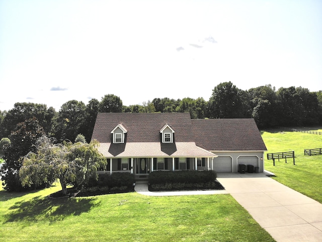 cape cod-style house featuring a garage, driveway, a front yard, and fence