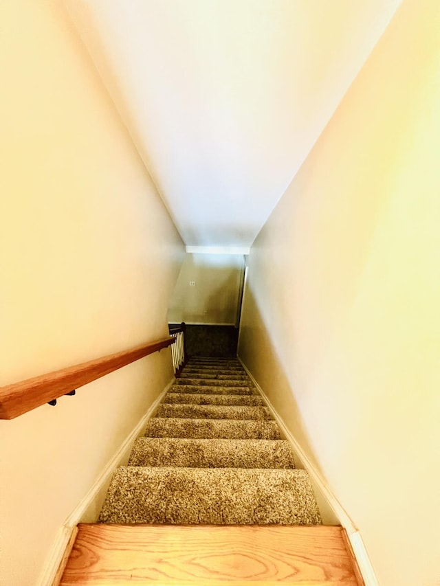 staircase with lofted ceiling and baseboards