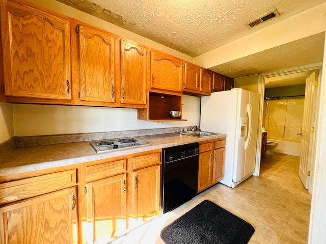 kitchen featuring black dishwasher, visible vents, a sink, white fridge with ice dispenser, and stainless steel stovetop