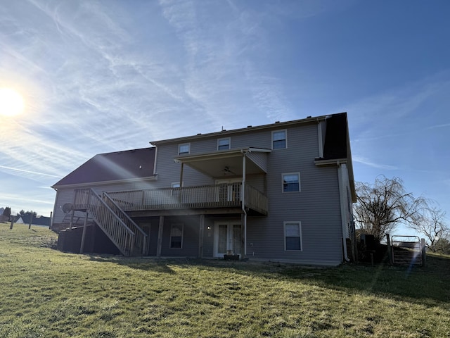 back of property with stairway, a lawn, and a wooden deck