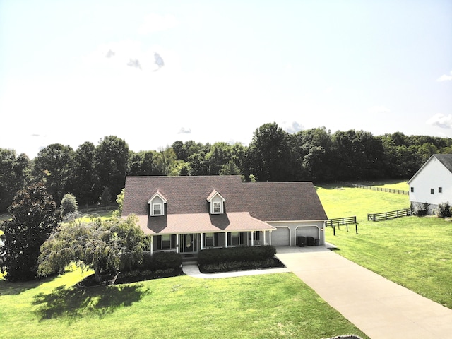 cape cod-style house with concrete driveway, fence, a front lawn, and an attached garage