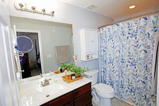 bathroom featuring vanity, walk in shower, tile patterned floors, and toilet