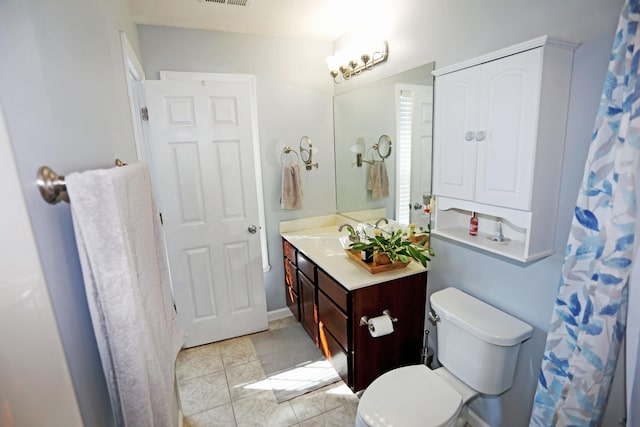 bathroom featuring tile patterned flooring, vanity, and toilet