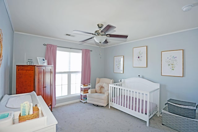 carpeted bedroom featuring a crib, crown molding, and ceiling fan