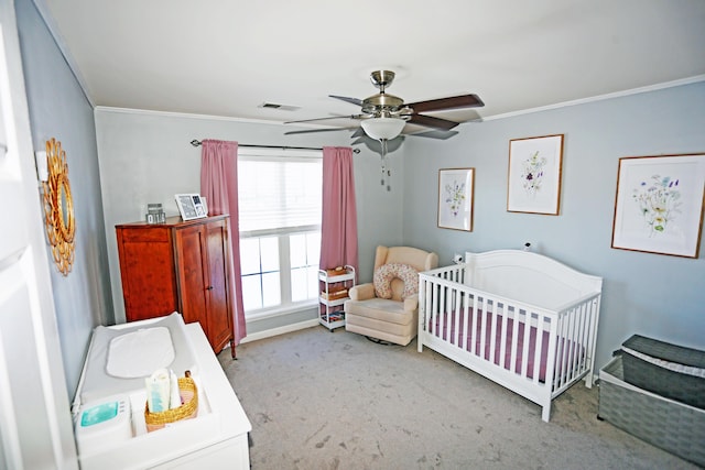 bedroom with a nursery area, ceiling fan, ornamental molding, and light colored carpet