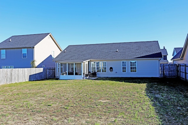 back of property with a lawn and a sunroom