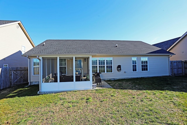 back of property with a patio, a sunroom, and a lawn