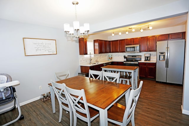 dining area with sink, a notable chandelier, and dark wood-type flooring