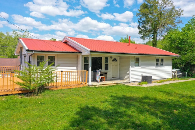 rear view of property featuring a lawn and a wooden deck