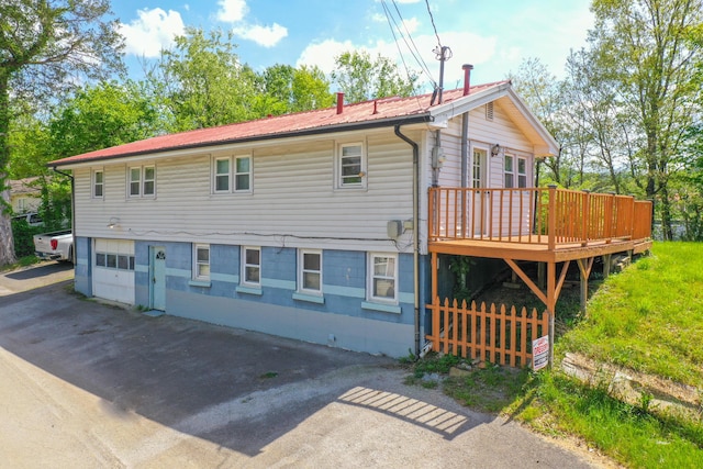 back of house with a garage and a deck