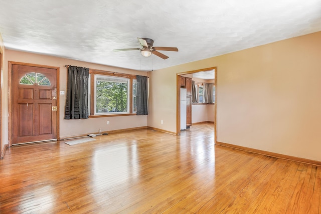 unfurnished living room featuring ceiling fan, a textured ceiling, and light hardwood / wood-style flooring