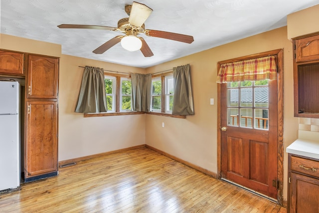 kitchen featuring ceiling fan, white refrigerator, and light hardwood / wood-style flooring