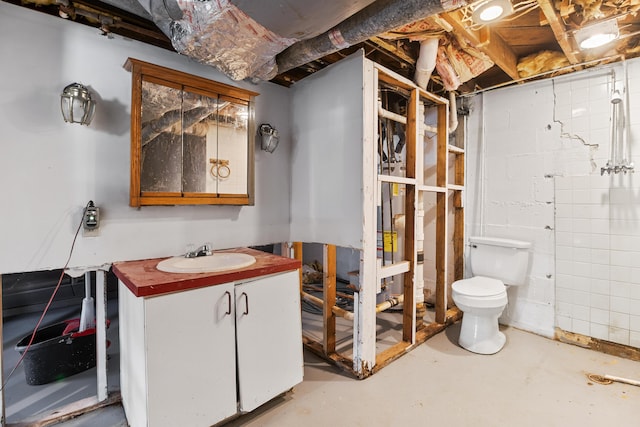 bathroom with vanity, toilet, and concrete floors