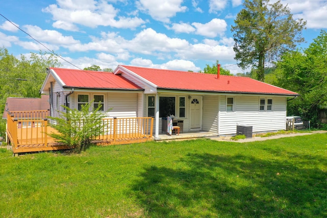 back of property with a wooden deck and a yard