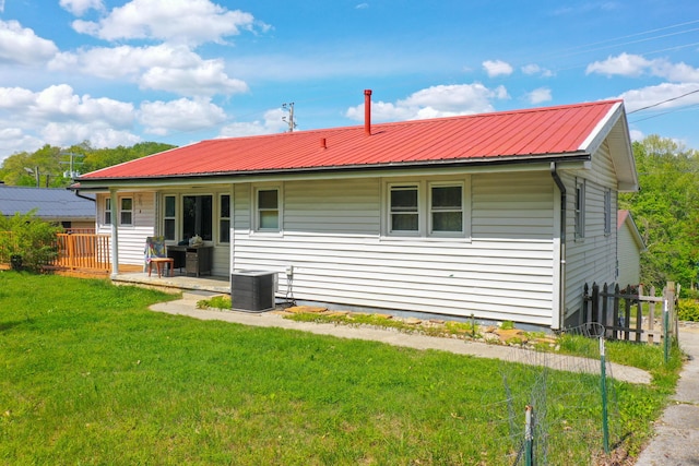 rear view of house with a lawn, a porch, and central air condition unit