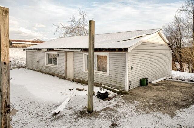 view of snow covered back of property