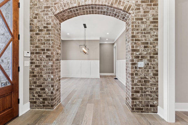 foyer featuring light wood-type flooring and ornamental molding