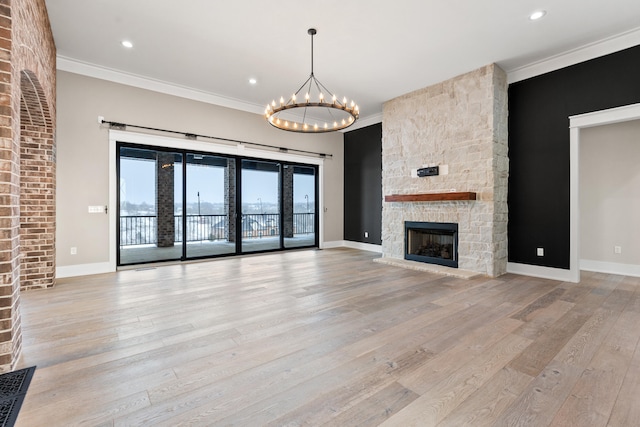 unfurnished living room with a fireplace, light wood-type flooring, and ornamental molding