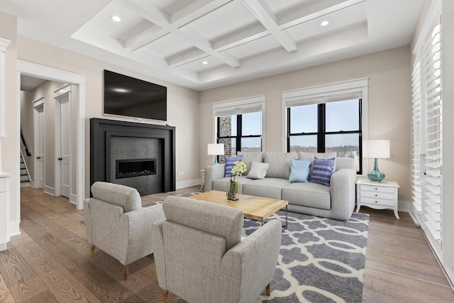 living room with coffered ceiling, light hardwood / wood-style floors, and beam ceiling