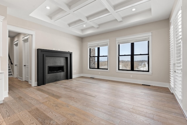 unfurnished living room with light hardwood / wood-style floors, beam ceiling, and coffered ceiling