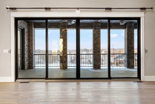 doorway with a wealth of natural light and hardwood / wood-style floors