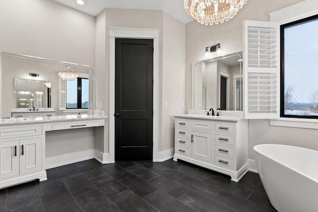 bathroom with a bathing tub, a notable chandelier, and vanity