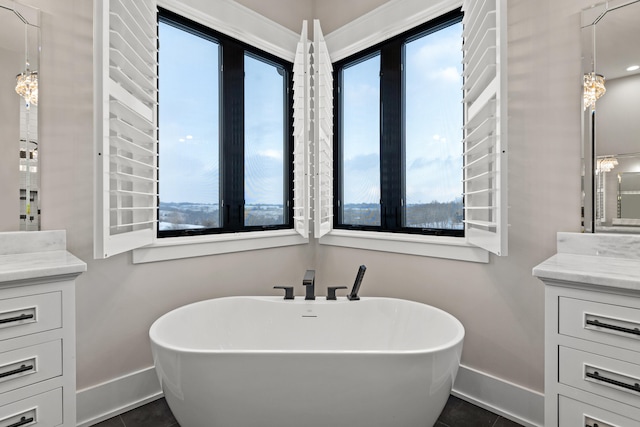 bathroom with a tub to relax in, tile patterned flooring, and vanity