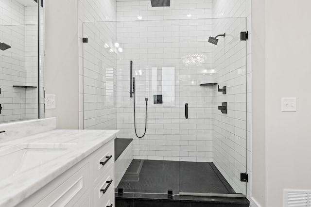 bathroom with a shower with door and vanity