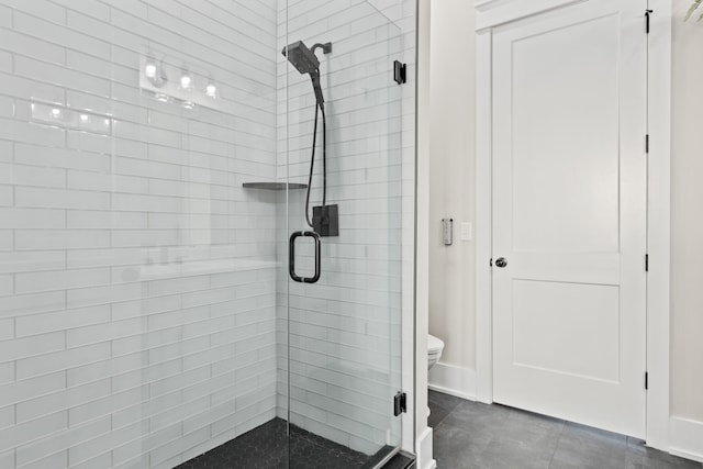 bathroom with toilet, tile patterned floors, and a shower with shower door