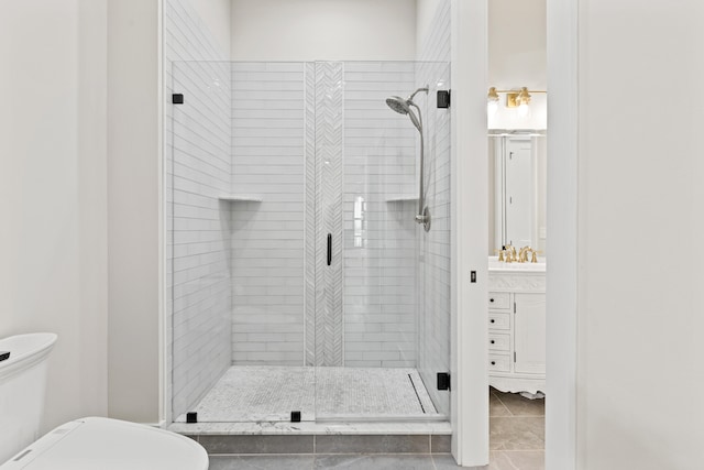 bathroom featuring a shower with door, toilet, and vanity