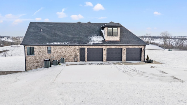 snow covered property with central AC unit