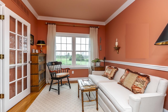 living room featuring ornamental molding and light hardwood / wood-style floors