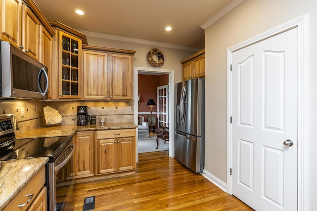 kitchen featuring appliances with stainless steel finishes, dark hardwood / wood-style floors, tasteful backsplash, ornamental molding, and light stone counters