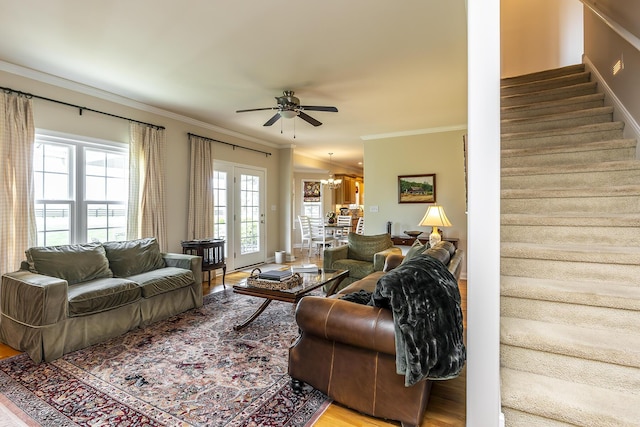 living room featuring crown molding, ceiling fan with notable chandelier, and hardwood / wood-style flooring