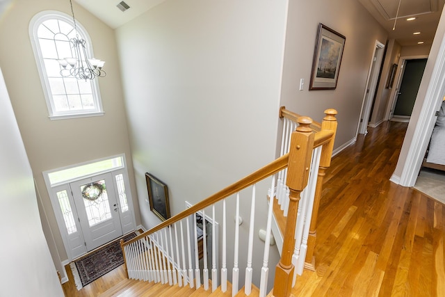 foyer entrance with wood-type flooring and a notable chandelier