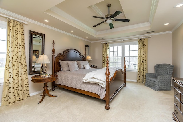 bedroom featuring crown molding, light carpet, ceiling fan, and a tray ceiling