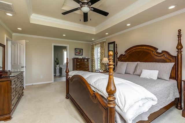 carpeted bedroom featuring ceiling fan, ornamental molding, a tray ceiling, and ensuite bath