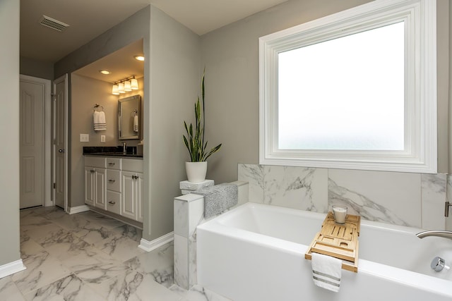 bathroom with vanity and a washtub