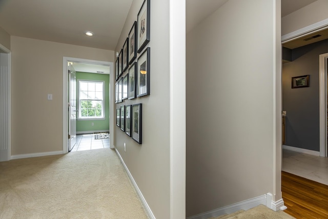 hallway featuring light colored carpet