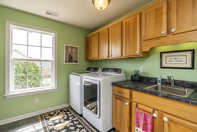 clothes washing area with cabinets, separate washer and dryer, sink, and a wealth of natural light