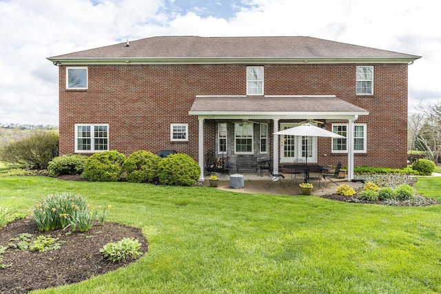 rear view of house with a yard and a patio