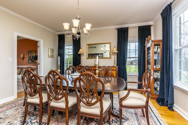 dining room with a notable chandelier, a healthy amount of sunlight, and light wood-type flooring