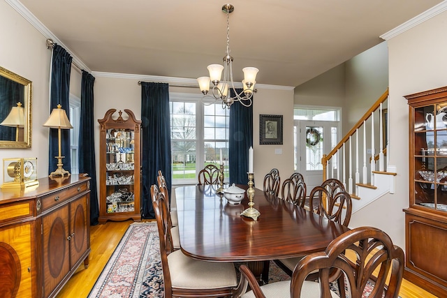 dining space featuring crown molding, a chandelier, and light hardwood / wood-style floors