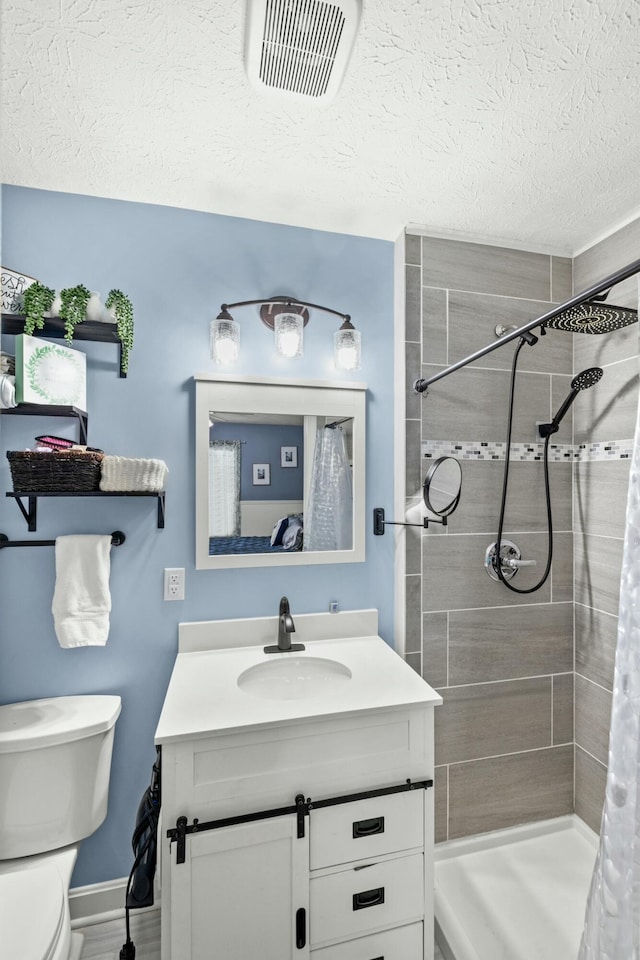 bathroom featuring vanity, toilet, a textured ceiling, and a shower with curtain