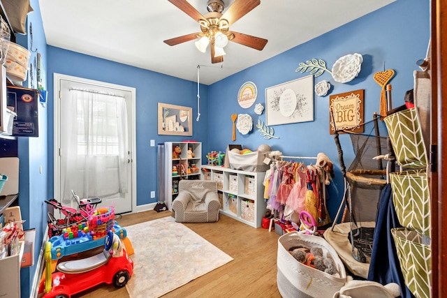 rec room with ceiling fan and light hardwood / wood-style flooring