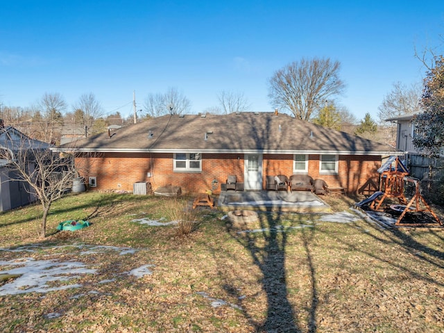 rear view of property featuring central AC unit, a yard, a patio area, and a playground