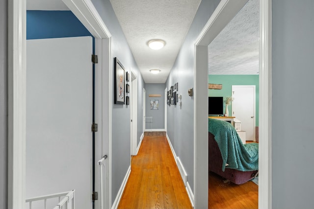 hallway with wood-type flooring and a textured ceiling