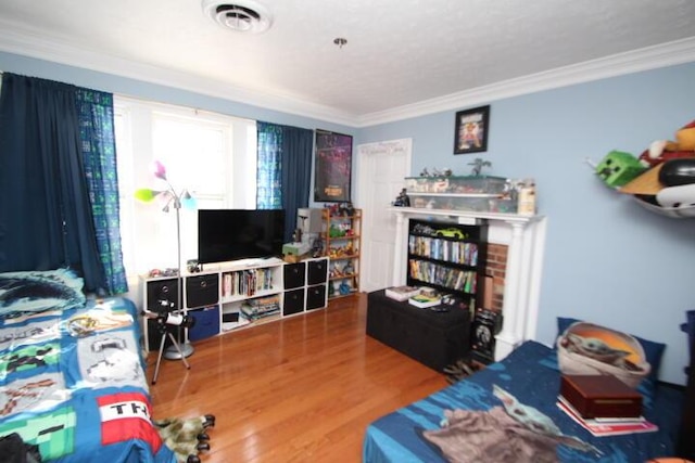 living room featuring visible vents, ornamental molding, and wood finished floors